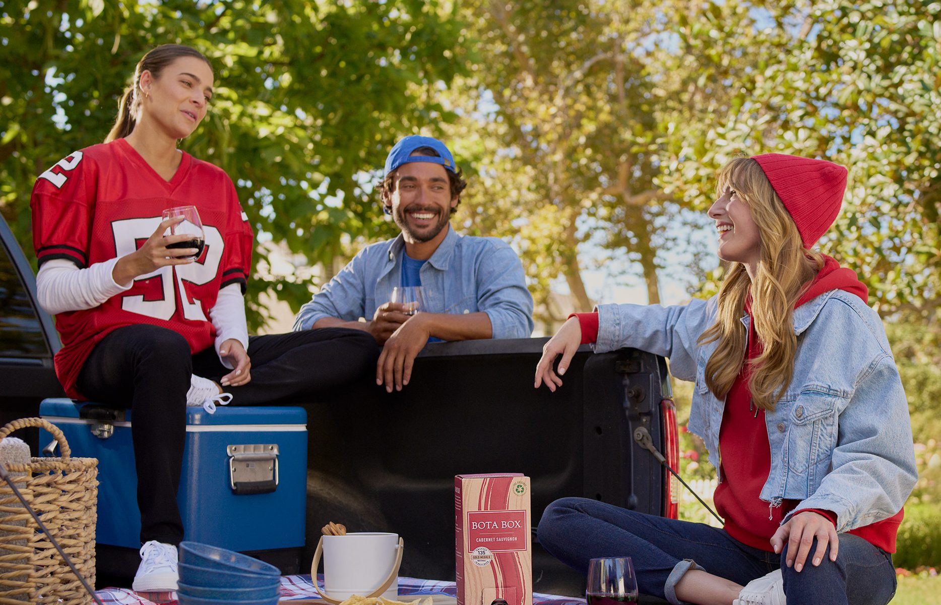 Photo of people drinking wine in the back of a pickup truck